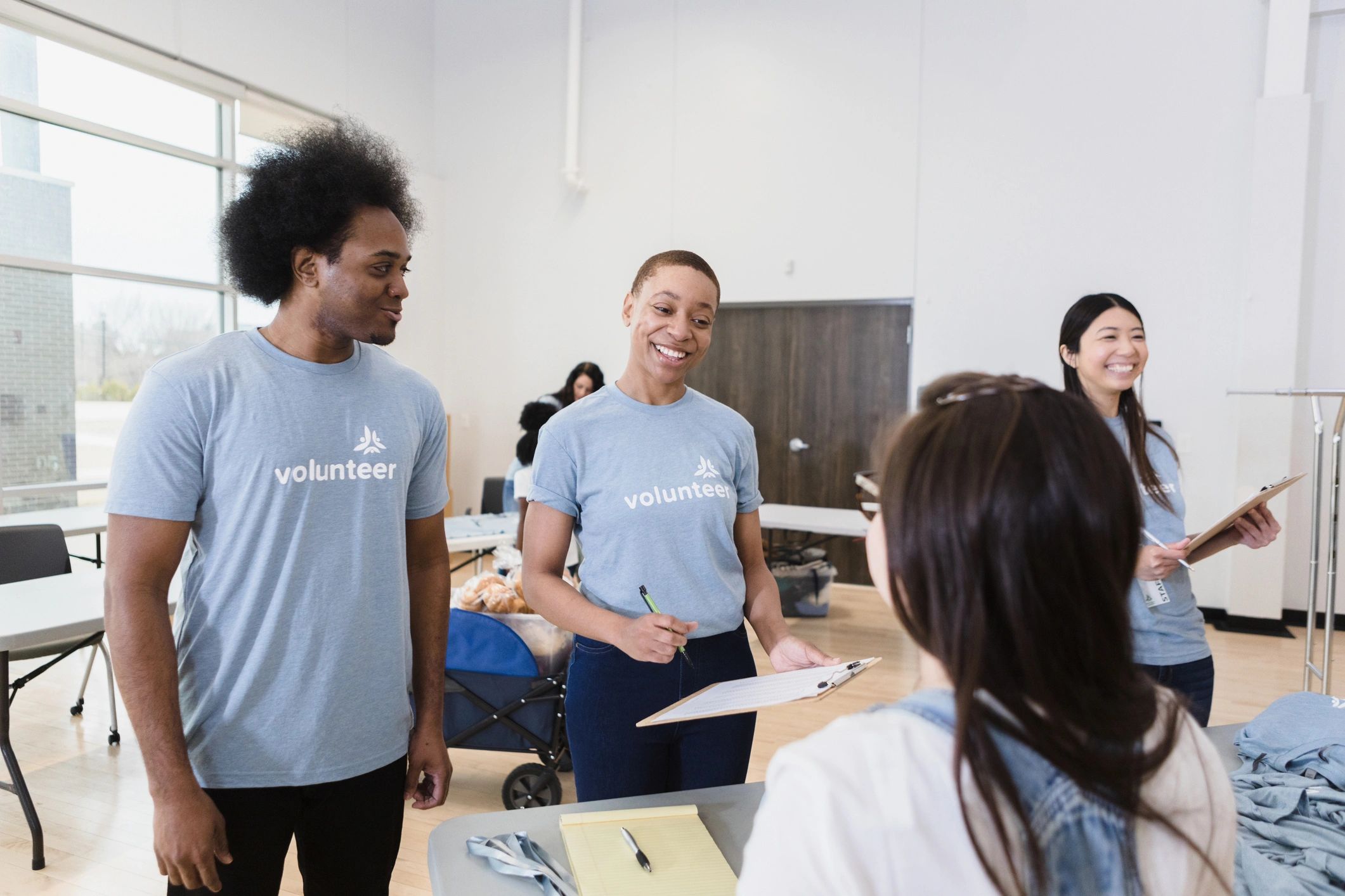 Volunteer helping a young person register at a community event