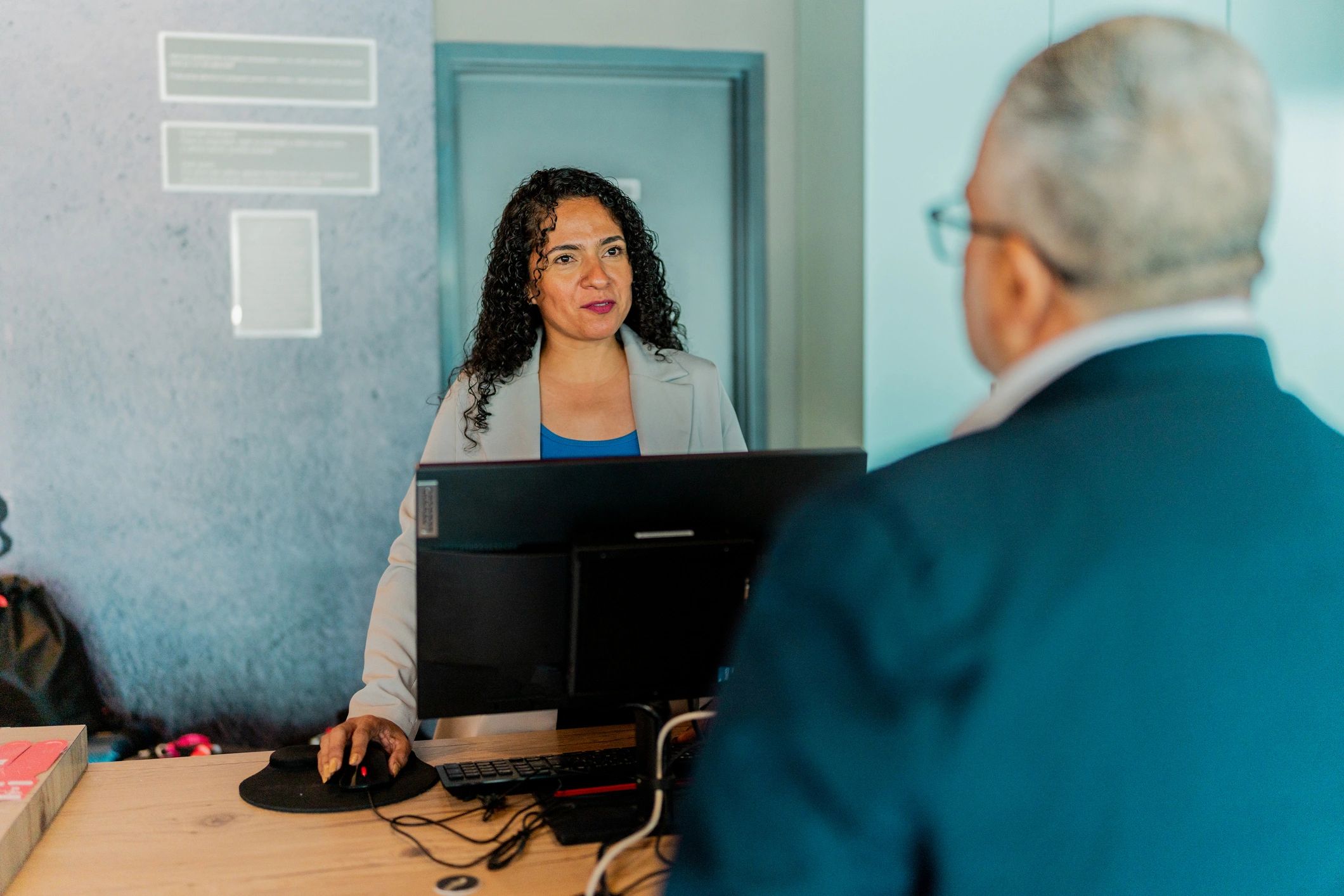 Front desk staff assisting a visitor during check-in